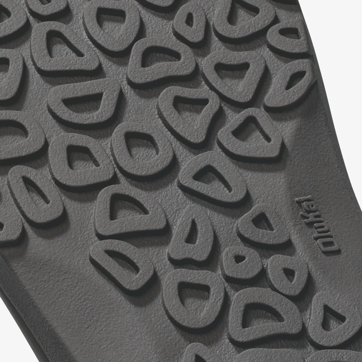 Gray rubber sole with raised canoe and rock-shaped tread pattern and brand marking.