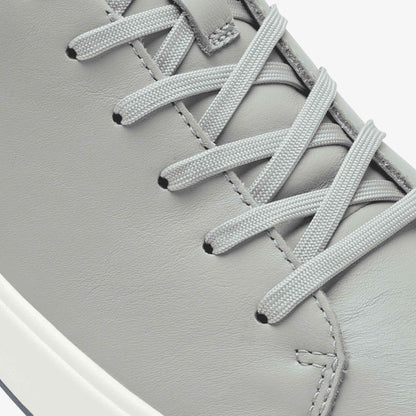 Grey leather sneaker with white laces and white sole detail.