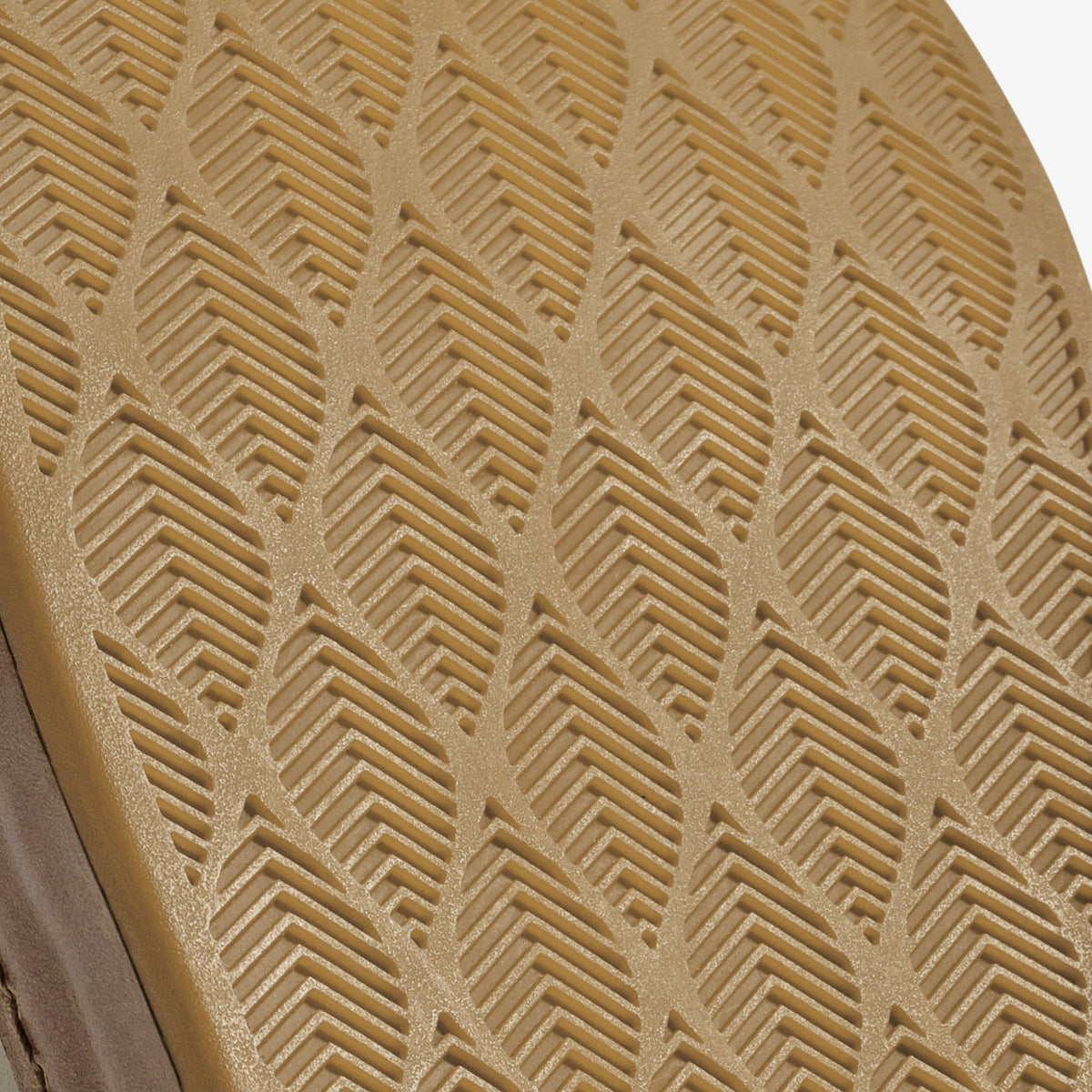 Tan clay textile with raised geometric chevron and linear pattern detail.