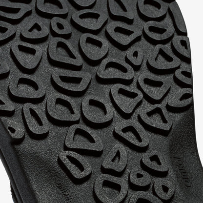 Close-up of textured sole with repeating geometric cutout pattern in gray and black tones.