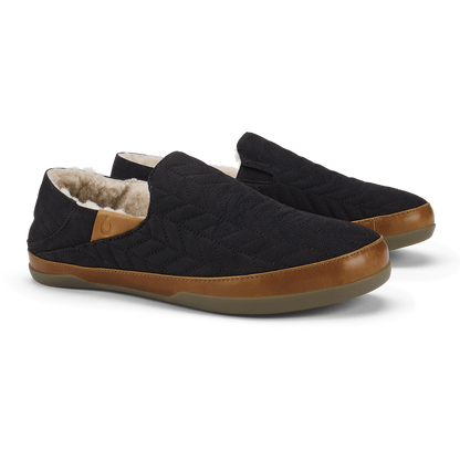 Black quilted slip-on slippers with tan leather trim and fleece lining.