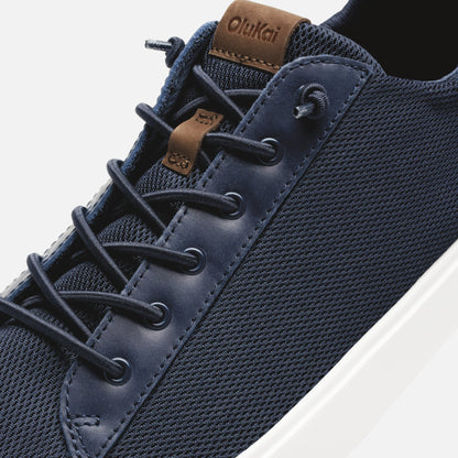 Trench blue lace-up shoe with mesh upper, navy leather toe cap, brown suede tongue label, and white sole.
