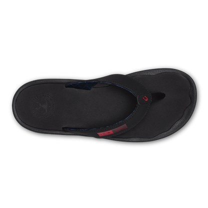 Black flip-flop thong sandal with textured sole and red accent strap detail, viewed from above.