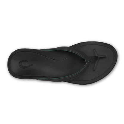 Black lava rock thong sandal with green accent strap viewed from above.