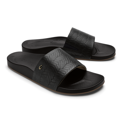 Black woven slide sandals with textured straps and cushioned footbeds.