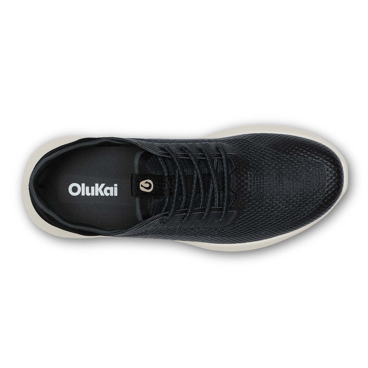 Black mesh OluKai sneaker with lace-up closure and cream-colored sole, viewed from above.