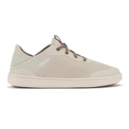 Cream-colored low-top sneaker with perforated mesh upper, brown laces, and cream rubber sole.