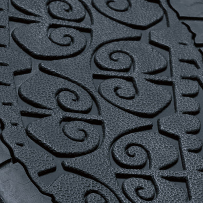Dark textured surface with embossed spiral and geometric patterns in relief.