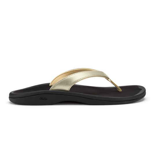 Gold metallic thong strap sandal with black cushioned sole and curved footbed.